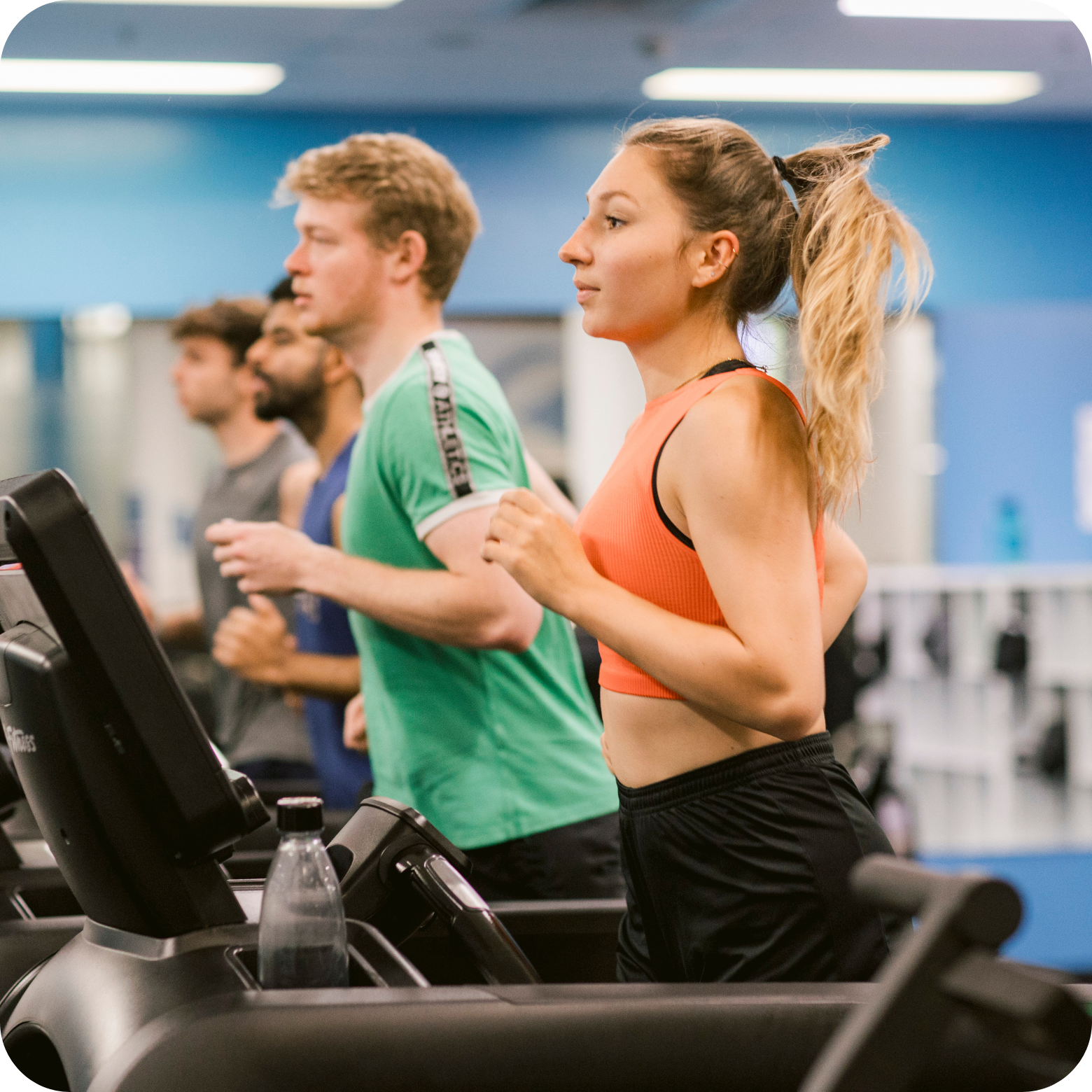 Gym members running on treadmills